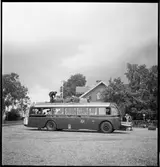 Gengasdrivenbuss. Lastning av bagage på busstaket.