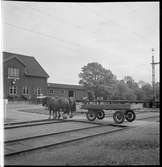 Häst och vagn passerar bangården i Lindome.