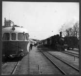 Ett rälsbusståg och ett ångtåg på Västervik station.