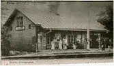 Statens Järnvägar, SJ  Detta fotografi har särskilt framställts efter ett gammalt vykort  genom förmedling av Jularbo  fotografister anstalt, innehavare HJ.Eriksson som skänkt det till historiken över Jularbo station. Omstånde foto, som efter stora ansträngningar av f.d. stins Dubois letades fram ur gammla gömmor, härstammar från år 1904 den 23n mars. Var god lägg märke till dom blommande prydnadsbuskarna, vilka sålunda förtäljer om den ridiga våren det året. Interessnt är den dåtida infartssignalen  med dess plsering mittför stationshuset. Till höger om infartssignalen står Stins Dubois samt intill honom,tillsammans med sin lilla son, står stfru Lilja.Sonen Rickard är numera förste kontorist på Biljettexpeditionen vid Stockholms central. Fotogenlycktan på stationshusets vägg talar om hur belysningsförhållanden på den tiden voro ordnade efter de dåtida resursern som stodo till buds.Det gamla förmäma stationshuset är alltjämt då detta skrivs i bruk.Dess stillsamma och behagliga