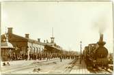 Nässjö station år 1898 med tåg och resande. Folksamling på plattformen.