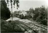 Text på bilden - Skogstorp station med OFWJ - tåg. 
 OFWJ är förkortning för Oxelösund - Flen - Västmanlands Järnväg.