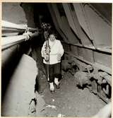 Statens Järnvägar, SJ, SJ Mas malmvagn, efter urspårning den 17/4 1956 på sträckan mellan Vassijaure och Hundalen. En kvinna går igenom tunneln där vagnarna spårat ur.