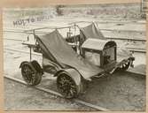 Fyrhjulig dressin med tvåcylindrig luftkyld bensinmotor. Magnetelekrisk tändning. Vikt cirka 285 kilo.