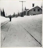 Stationsområde med vy på bangård och personal som utför snöröjning.