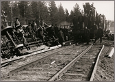 Personal som sitter på liggande godsvagnar efter olycka mellan Gastsjön och Kälarne i Jämtland på 1920-talet.