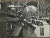 Dubbelspårsbyggnaden mellan Alingsås - Olskroken. Bron över Säveån södra brohalvan. Dykare i arbete med stenupptagning för spånten.