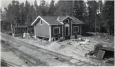 Långsjön under ombyggnad. Långsjö-Pelle till vänster framför huset tillsammans med övrig arbetskraft. Kuren till vänster i bild.