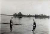Karin och Siri, midsommaren 1935. På norrsidan av sjön syns torpet Engvalls.