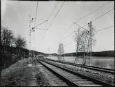 Kontaktledning för dubbelspårig sträcka. På linjen vid Vik strax söder om Norsesund. Sjön Sävelången.