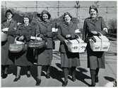 Rödakorssystrar samt personal från Lottakåren på Hallsbergs station under Andra Världskriget redo med förnödenheter till krigsskadade, i samband med att ett tyskt sjukvårdståg ska passera.