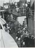 Krigsfångar som blir tilldelade påsar med förnödenheter ombord, på S/S Drottning Wictoria, från Röda Korset.