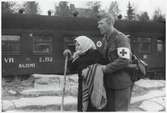 Finsk flykting får assistans av militärsjukvårdare i Haparanda, hösten 1944. Valtionrautatiet (Statsjärnvägarna), VR 22192.