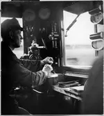 Lokförare i förarhytten på ellok.