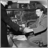 Busschaufför tar emot betalning för en bussresa.