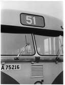 Nummerskylt och framruta med vindrutetorkare på en buss.