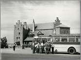 Resande med turistbuss Scania-Vabis 1947 utanför värdshuset Gyllene Uttern.