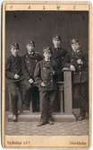 Nummer 4 från vänster är Adolf Herman Jönsson, som blev ordinarie kontorsvakt 1877. Övriga fyra män är okända.