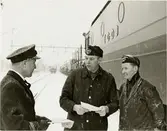 Emil Klerhult platsföreståndare vid stationen i Vrena, lokförare Evert Ahlin och medarbetaren vid stationen Uno Larsson. Elloket bakom är Trafikaktiebolaget Grängesberg - Oxelösunds Järnvägar, TGOJ Bt 307.
