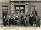 Utländska pressföreningen utanför Linköping station 15/5 1931. Järnvägspersonal syns i fönstret bakom gruppen