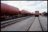 Statens Järnvägar, SJ V5 185 och öppna godsvagnar med last av cisterner på bangård.