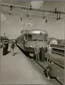 Gruppfoto framför rälsbusståg vid perrong.