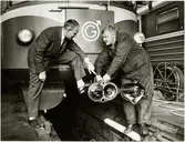 Verkmästare Folke Holmberg och reparatör Bo Elfkvist kontrollerar en koppling vid Trafikaktiebolaget Grängesberg - Oxelösunds Järnvägar, TGOJ verkstad i Eskilstuna.