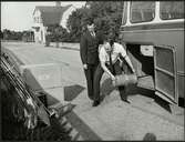 Personal hanterar gods från en Trafikaktiebolaget Grängesberg - Oxelösunds Järnvägar, TGOJ buss.