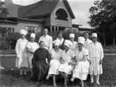 Societetsrestaurangens kökspersonal i societetsparken med restaurangbyggnaden i bakgrunden. En av männen är Oscar Johansson som brukade baka brödet till restaurangen.