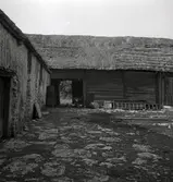 Ladugård med stråtak och vagnslider.