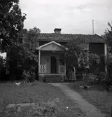 Gammal kvinna vid sin enkelstuga i Kalmar län.