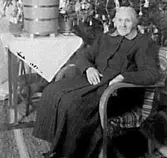 EN KVINNA I EN FÅTÖLJ FRAMFÖR EN JULGRAN