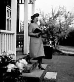 EN KVINNA SOM GÅR NEDFÖR EN TRAPPA OCH BÄR PÅ EN RESVÄSKA