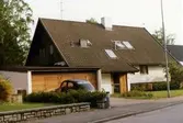 Bostadshus i vitt tegel och sadeltak på Bisterfeldtsvägen 15. Garage till vänster. Ägaren hette Adner och byggmästaren var Bertil Danielsson.