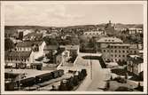 Vy på stad med del av bangård och med stadshuset i bakgrunden.