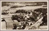 Flygvy över Etelhem med station och jordbruk i bild.