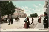 Handkolorerat vykort från gatan utanför järnvägsstationen i Lund.