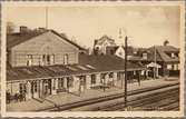 Stationsområde med resande på perrong.