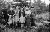 Granplantering på Järlöv gårds ägor. Från vänster: Karl Henriksson, okänd, Karl Snygg, Elin Svensson, Ingvar Henriksson i Lövagård, August Snygg, Anna Snygg, Gösta Svensson, Kerstin Henriksson i Dalenbäck, Gustaf Henriksson (bror till Karl H) och fotografen själv - Erik Andersson. Pojken kan vara son till en Alice och heta Lennart.