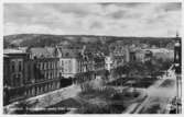 Motiv med Esplanaden sedd från söder. Från vänster Wikströmska huset, Sundsvalls Tidnings hus, Rönnholmska huset samt Centralhotellet. Vid gatans slut magasinshuset Fregattskeppet som revs 1973.