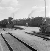 Två ånglok med vedeldning står vid plattformen vid Söderhamn station.