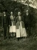Stående från vänster: Olof Bernhard Börjesson (f. 1854 Lindome d. 1931), Selma Börjesson (f. 1890 d. 1983), Emilia Augusta Magnusdotter (f. 1861 d. 1942) och Artur Börjesson, snickare (f. 1888 d. 1959) står vid torpet Hökekullen vid Horssjön, Vommedal Västergård 3:62, cirka 1920.
Bildtext på baksidan: Hökekullen, Selma och Artur med föräldrar.