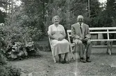Ett syskonpar sitter i en trädgård okänt årtal. Mannen till höger är Robert Pettersson (1886-1968). Han var dräng på Ekans gård.