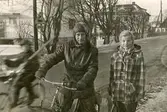 Gamla Riksvägen.
Knut jerkfelt 1906- 
m dotter Gun Britt Jerkfelt Eklund f. 1942.
I bakgrunden:
Villa Petershov.
Gustavsro Lanthandel, G:a Riksv. 48.
Taxistationen vid Kållereds Stationshus.