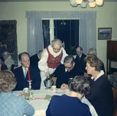 Kyrkokören på besök i Brattåshemmet år 1969.
Från vänster: kantor Bengt Forsberg, föreståndare Magda Andreasson (i folkdräkt) som serverar kaffe, Karl Olofsson och Ingrid Skansing.
Med ryggen mot kameran: Gunvor Eriksson samt okänd. I bakgrunden ses bl a Blomberg