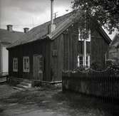 Figeholm, stuga med träfasad sadeltak, trappa och staket.