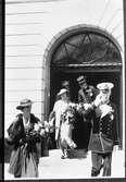Stora delar av den kungliga familjen är i Arboga med anledning av firandet av Sveriges Riksdags 500-årsjubileum. Kungligheterna har gjort ett kort besök i Rådhuset.
Från vänster; kronprinsessan Louise med svärfar kung Gustaf V. Bakom dem kommer prinsessan Sibylla med sin svärfar; kronprins Gustaf Adolf. Båda kvinnorna bär hatt och var sin stor blomsterbukett.
