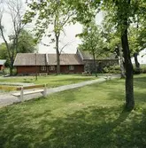 Del av Olof Ahllöfs park, Ahllöfsparken.
Trähus och stenbyggnad (senare kallad Sankta Karins kapell). Till vänster anas scenen och dammen. Bänkar är utställda efter promenadstigarna. Två personer sitter på en bänk.