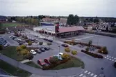 Arboga station vid Centrumleden. Resecentrum. Ett tåg kommer in på perrongen.
Utanför järnvägsstationen ligger parkeringsplatser för bilar och hållplatser för bussar.
Till vänster ses idrottsanläggningen Sturehallen och Sturevallen.
På andra sidan järnvägen ligger äldreboendet Trädgården. Bakom de höga träden skymtar Högskolecentrum.