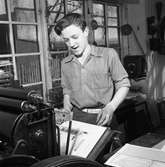 Arboga Tidning, interiör. En ung man, med uppkavlade skjortärmar, arbetar vid en maskin i tryckeriet.